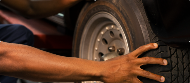 a man checking our a car tyre to ensure that is well-positioned