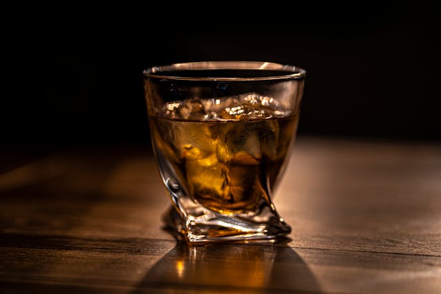 Best father's day gifts: A glass of whisky on a brown wooden table