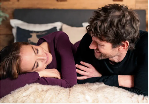 A couple relaxing on their bed with Dagsmejan comfortable sleepwear 