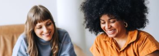 Two girls looking down and smiling as they are happy with Capital Office