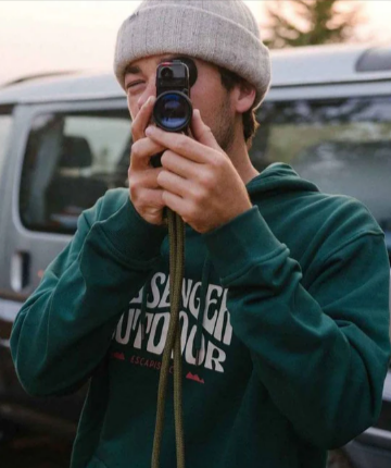 A man using a camera while wearing a beanie and hoodie from Fat Buddha Store