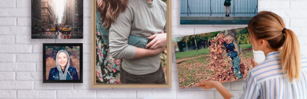 A lady hanging pictures of memories on her wall