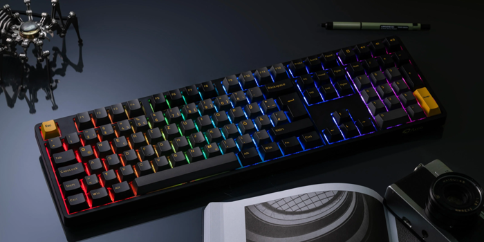 Eine schwarze Tastatur mit buntem Licht neben diversen Gegenständen
