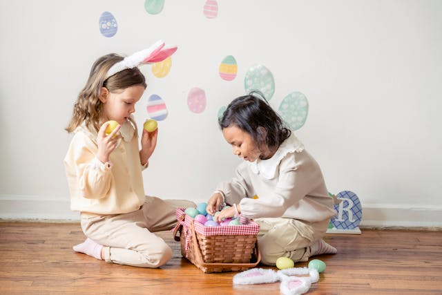 Fun school holiday activities: Two young children playing with Easter eggs in a basket
