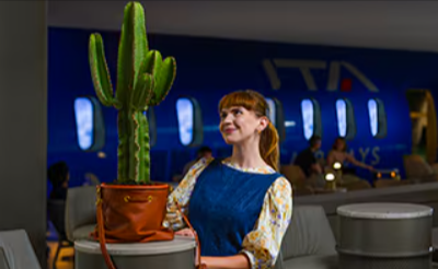hostess ITA Airways vicina ad aereo da prenotare con un codice sconto ITA Airways