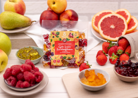 Eine Packung mit Gummibärchen von Naschlabor mit vielen Früchten drumherum