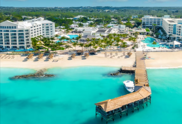 A beach front hotel in a resort area with palm trees surrounding the building