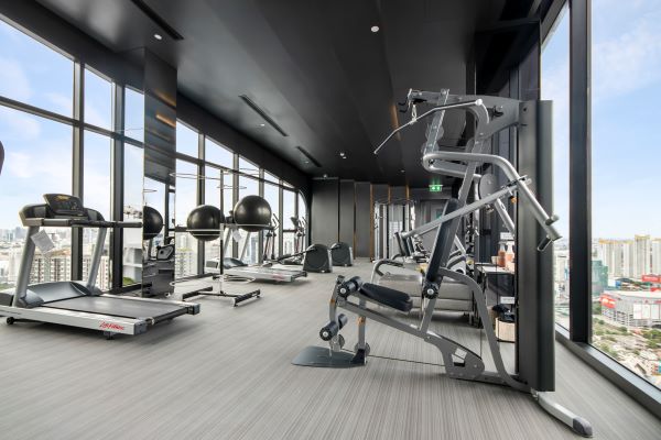 Modern gym with treadmills and weight machines with a city view