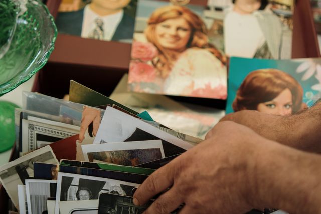 A person looking through family photos after learning their history through Genes Reunited
