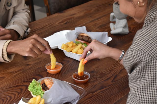 How to save money on food: A couple eating chips and burgers at a restaurant