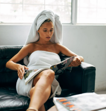Woman reading a magazine while sitting on a couch