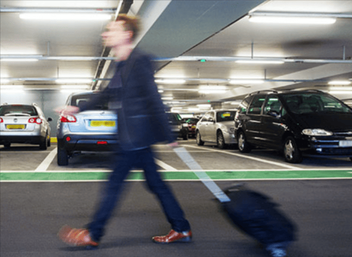 A traveller walking through the Heathrow Airport Parking parking lot after he save on parking with a Heathrow Airport Parking voucher code from Love Discount Vouchers