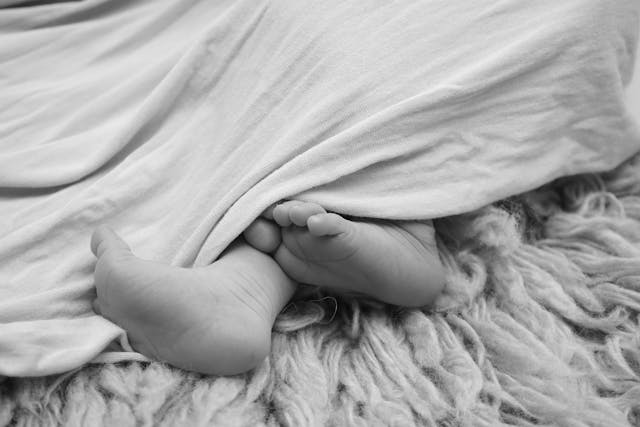 A baby laying on a blanket from CuddleCo