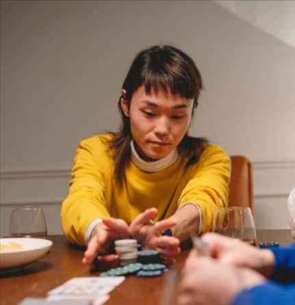 Woman in yellow sweater pushing her poker chips