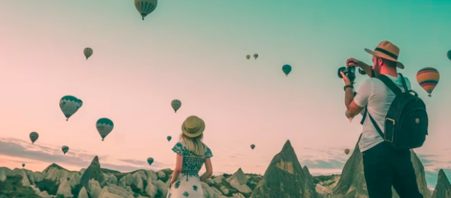 baloons in the dessert air and two people exploring the land