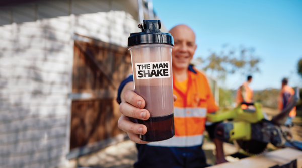 The Man Shake shake in a bottle with their branding on it and men in the background