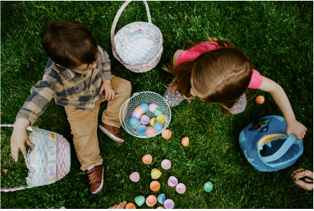 A boy and a girl sorting Easter eggs in their baskets