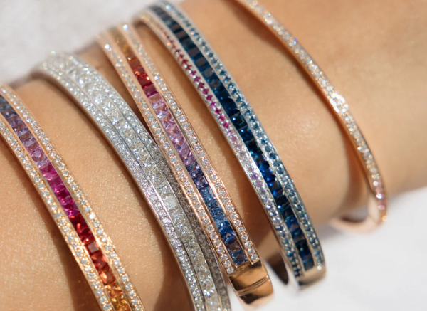 A person's wrist with multiple bangles in different colours and styles