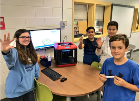 Students participating in a group project using a Flashforge 3D printer