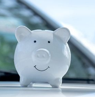 hucha de cerdito blanco sobre un coche de budget blanco