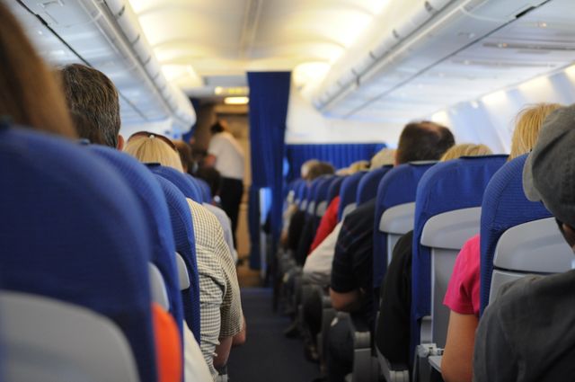 Interior view of an airplane cabin with passengers seated, showcasing air travel experience