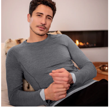 A man wearing a grey top, relaxing in his home