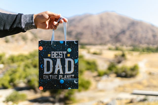 Best father's day gifts: A person holding a blue space gift bag