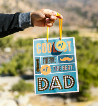 Person carrying a blue Father's Day paper bag