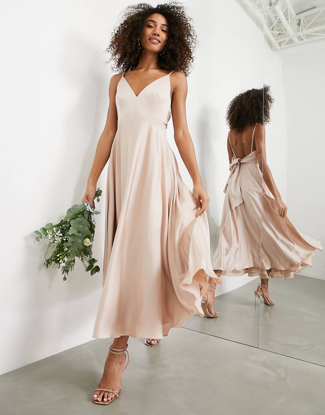 A woman holding a bouquet while trying on ASOS bridesmaid dresses