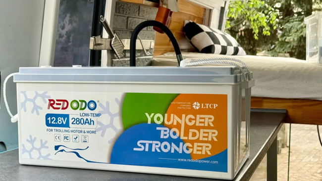 Eine große Batterie von Redodo auf einem Tisch vor einem Bett