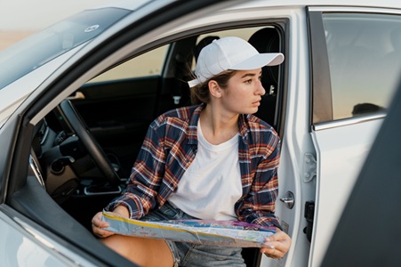 image showing a lady carrying a map in a car