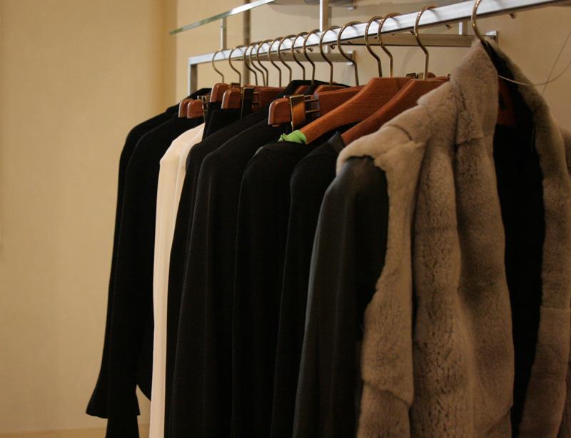 Diversi outfit della  marca Base Blu situati con delle grucce nello shop Base Blu di Varese