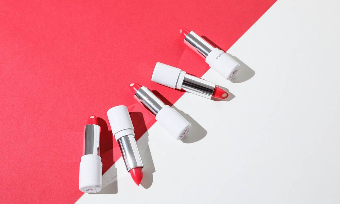 Mehrere rote Lippenstifte auf einem rot-weißem Hintergrund