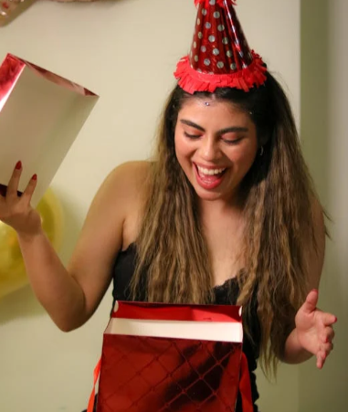 donna che scarta un regalo acquistato in offerta con un codice sconto Giorno Internazionale Della Donna