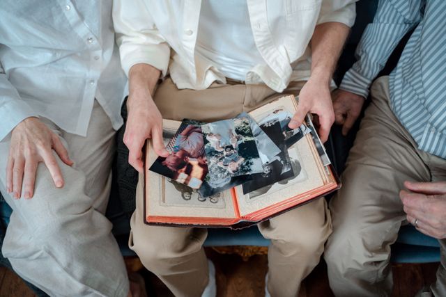 People looking through family photos after saving on their fmaily tree with a Genes Reunited voucher code