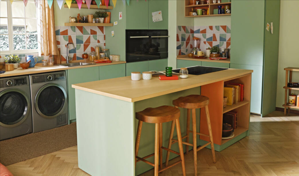 A kitchen equipped with sage green cabinets and a central island