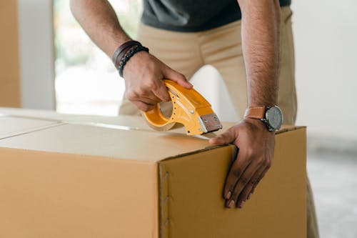 A man closing a parcel from Parcel ABC.