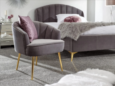 A bedroom with a grey headboard and bed base suite and a grey side chair