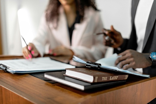 image showing two solicitors with a pile of law books on the table