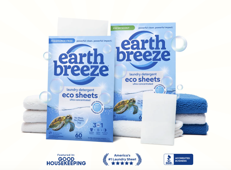 Two boxes of Earth Breeze Eco Laundry Sheets resting on a folded stack of towels