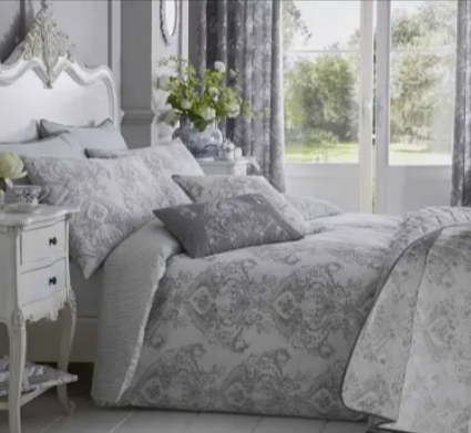 A grey French toile patterned duvet cover set from the luxury bedding collection in a white bedroom on a summer afternoon