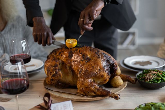 A person cutting a roast turkey that they saved on with a Thanksgiving promo code from Love Coupons