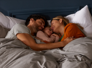 A family sleeping together on the DreamCloud luxury hybrid mattress