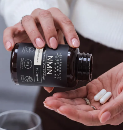 A person taking a nurtritional supplement from Harrogate Organics