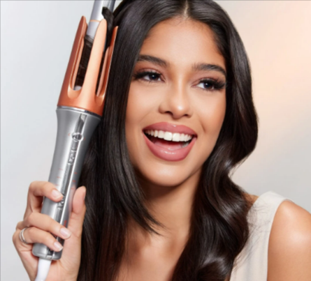 A lady styling her hair with a SHEGLAM It-Curl One-Touch Instant Curler