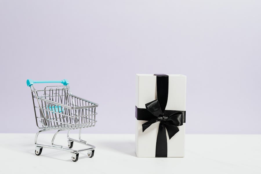 An empty shopping cart with a black ad white present next to it
