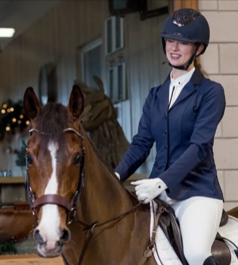 A rider wearing a blue HKM aurora competition jacket