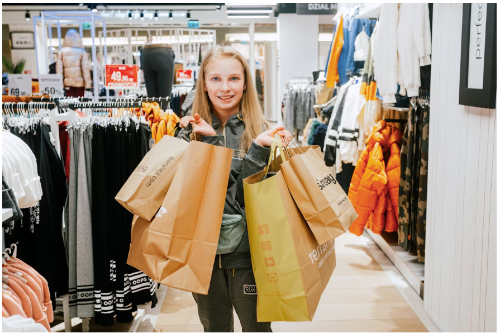 A woman holding several shopping bags after using different coupon codes