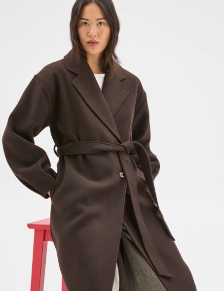 Dark brown coats:  A model wearing a truffle brown wrap belted coat