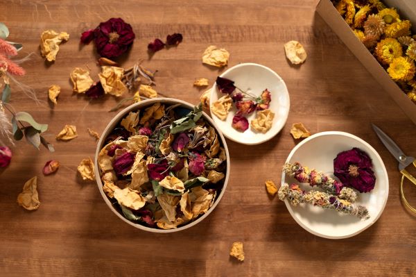 Dried flowers and petals in bowels on a wooden surface